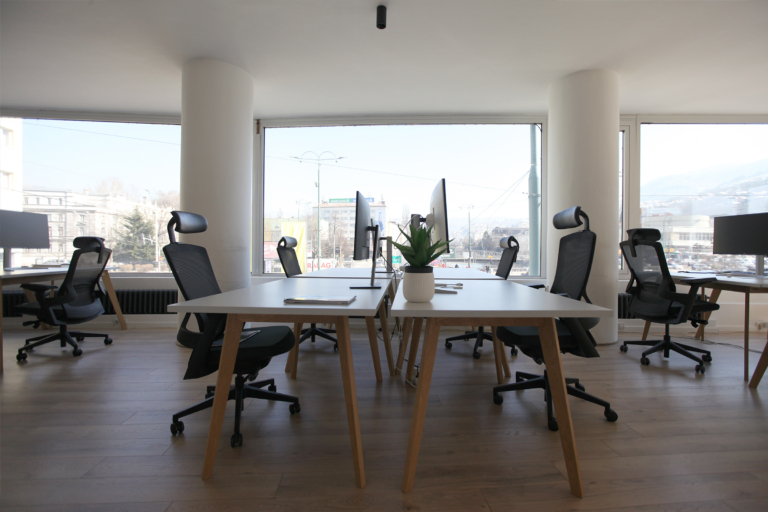 Modern coworking space in Sarajevo featuring desks, computer monitors, and office chairs
