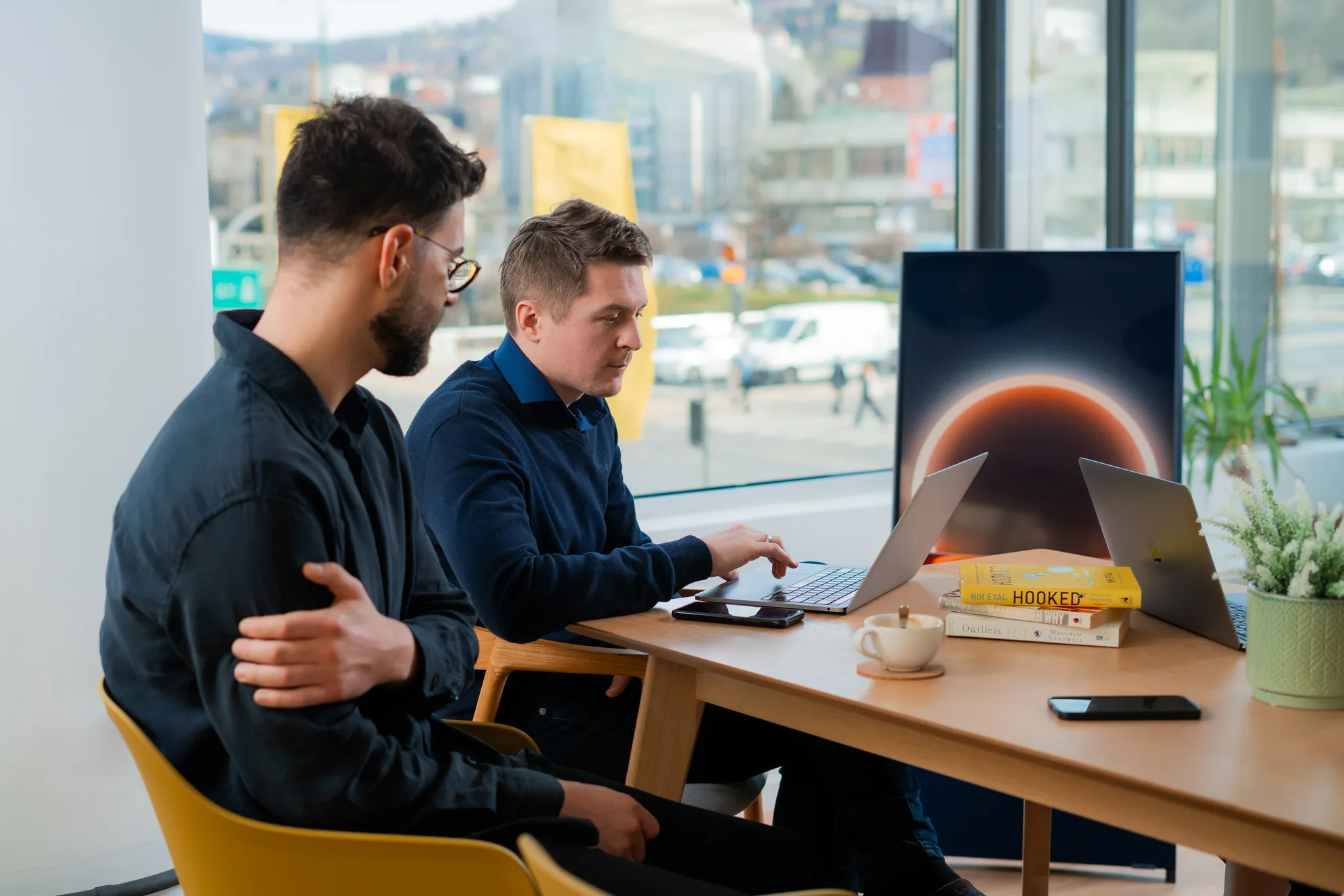 Colleagues reviewing work together on a laptop at a desk in Motiff coworking space in Sarajevo