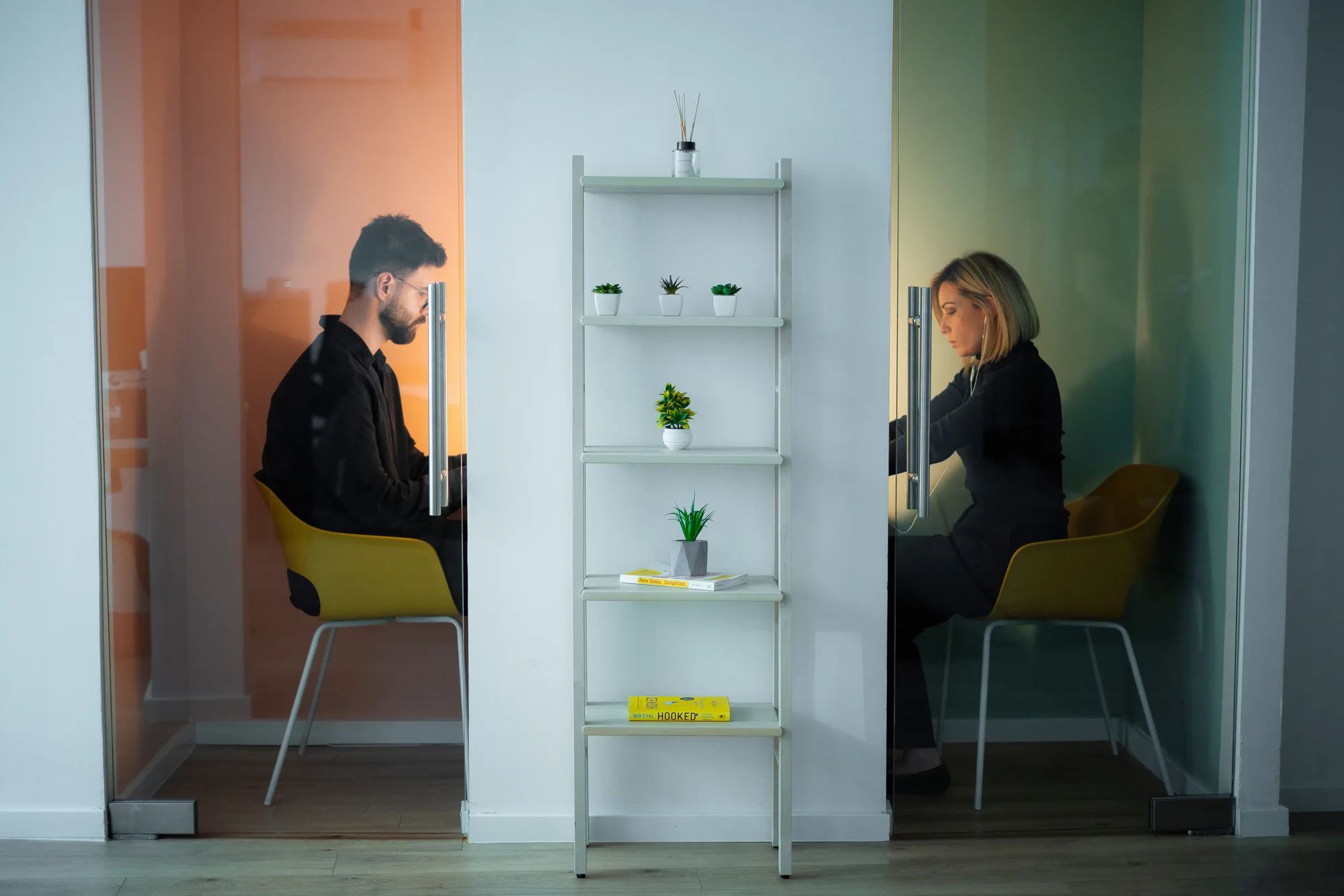 Two people making private calls in separate phone booths at Motiff coworking space in Sarajevo