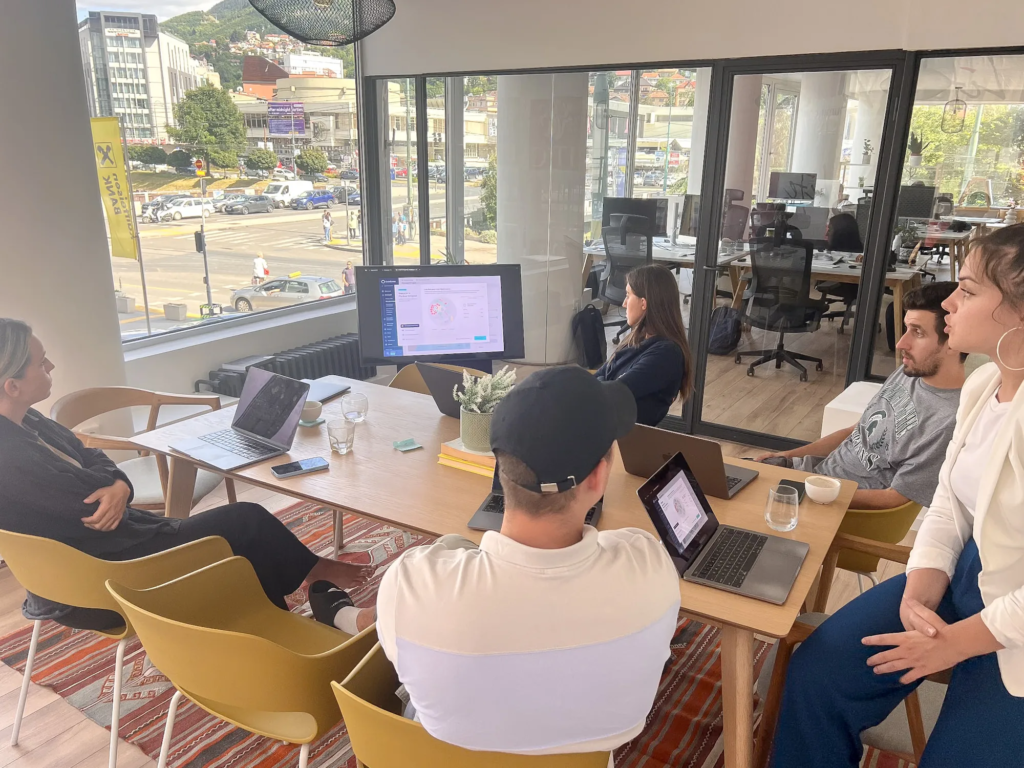 Team members with laptops gathered around a table during a meeting at Motiff coworking space
