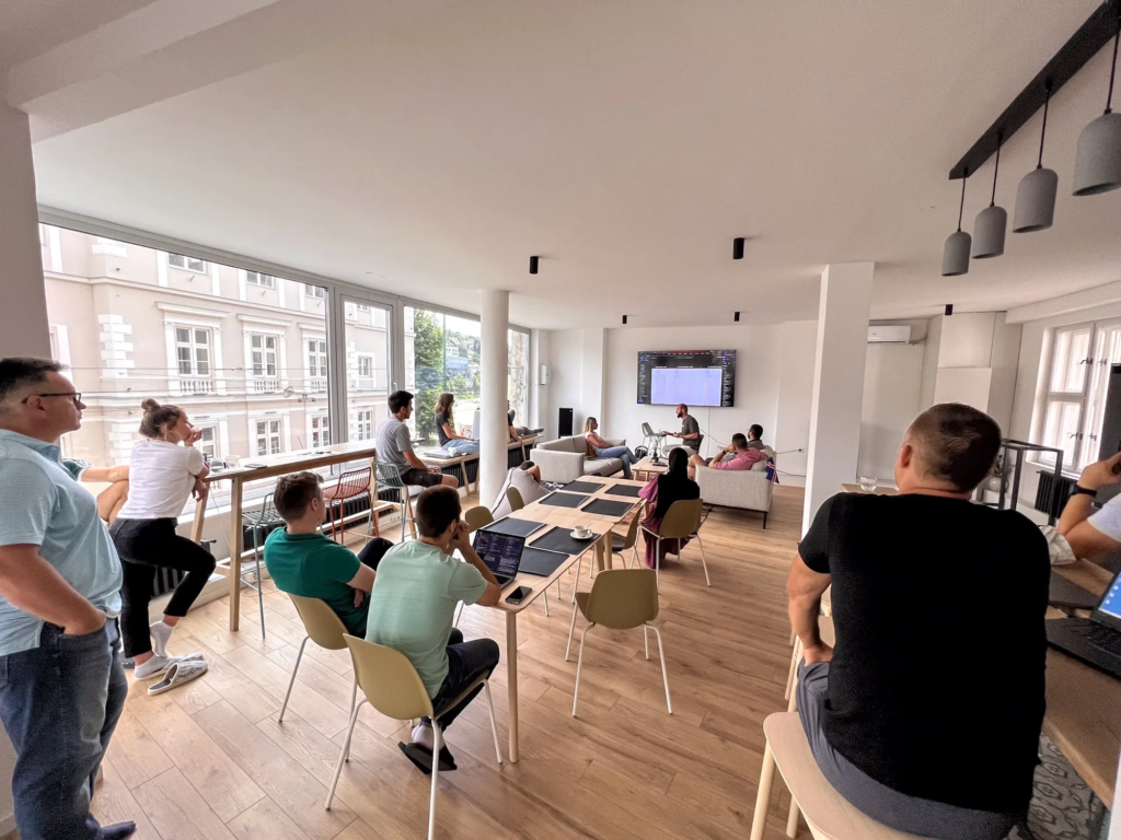 Team attending a workshop session with a presentation screen, large windows overlooking Sarajevo, at Motiff coworking space