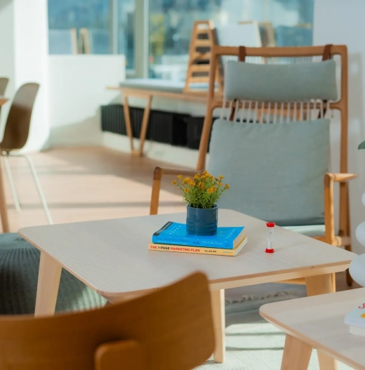 Lounge area with chairs, tables, and natural light from large windows in a modern coworking space in Sarajevo.